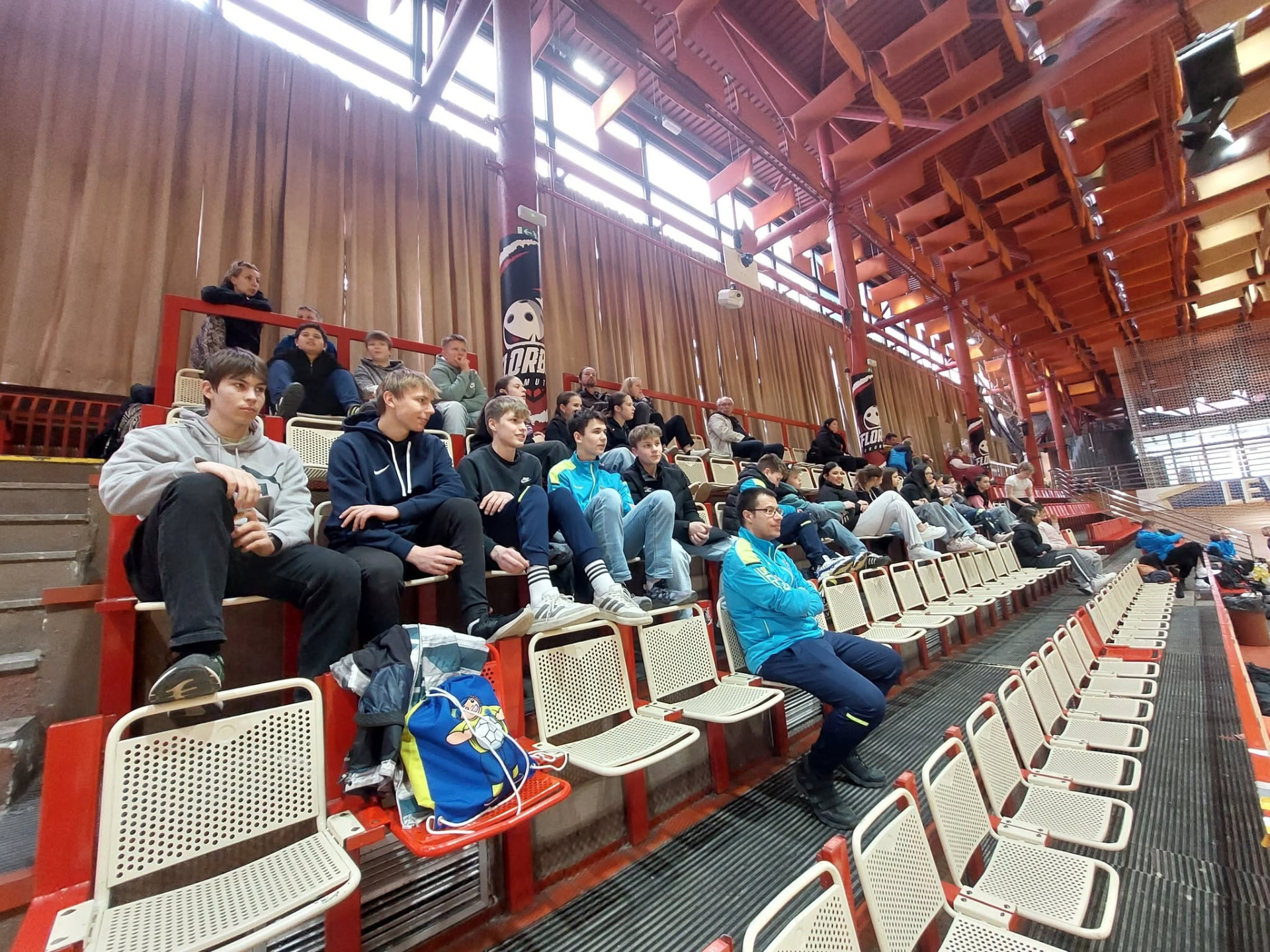 Fanoušci a hráči na tribuně v hale